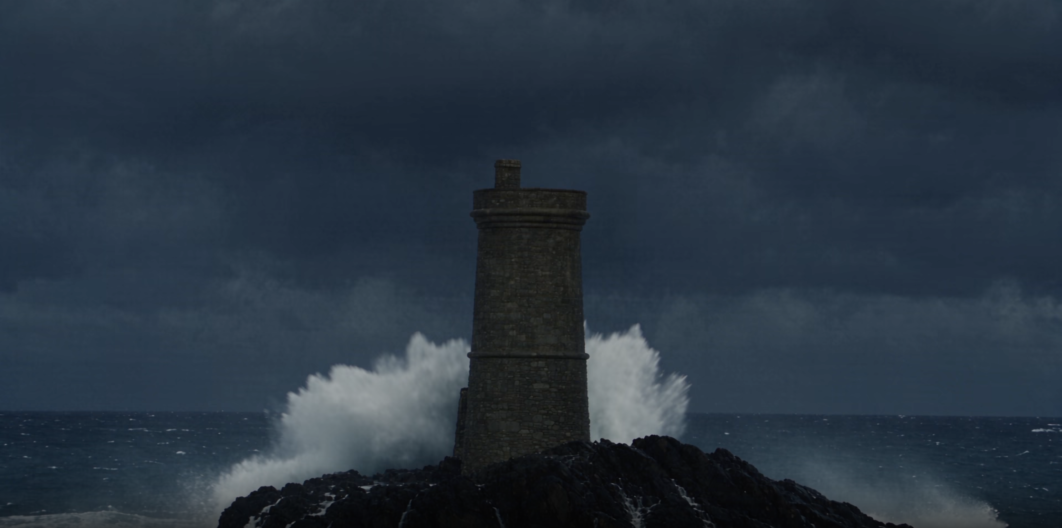wave crashing behind lighthouse